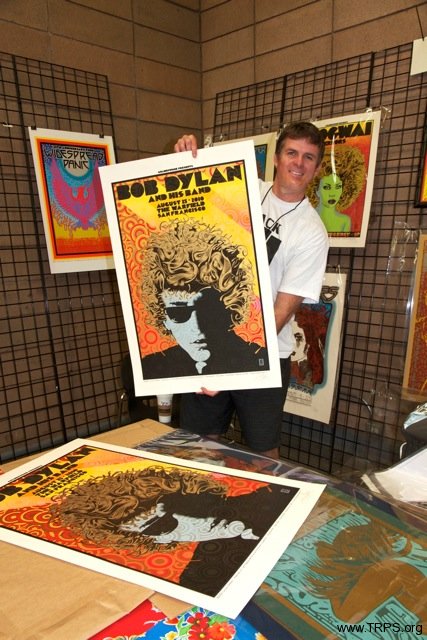Ben Clarke showing off a Bob Dylan rock poster by Chuck Sperry